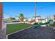 Wide backyard with a covered patio, lounge area, and play structure at 2088 Miner Way, Las Vegas, NV 89104