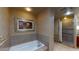 Well-lit bathroom featuring a soaking tub and glass-enclosed shower at 211 E Flamingo Rd # 202, Las Vegas, NV 89169
