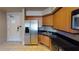 Functional kitchen area with stainless steel refrigerator, black countertops, and light wood cabinets at 211 E Flamingo Rd # 202, Las Vegas, NV 89169