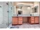 Bathroom featuring double sinks, wooden cabinets and a glass enclosed shower with marble tile at 2325 Windmill Pkwy # 1622, Henderson, NV 89074