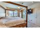 Bedroom featuring a four-poster bed, TV, shelf, and a door to a balcony at 2325 Windmill Pkwy # 1622, Henderson, NV 89074