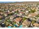 A high-angle aerial view of a residential community, featuring numerous houses with swimming pools and green spaces at 249 Cinnamon Ridge Way, Henderson, NV 89015