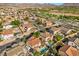 Aerial view of a residential area showcases homes, roads, and golf course surrounded by desert landscape at 249 Cinnamon Ridge Way, Henderson, NV 89015