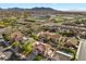 Expansive aerial view of a residential area with multiple houses, pools, and a view of distant mountains at 249 Cinnamon Ridge Way, Henderson, NV 89015