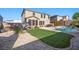 Spacious backyard with lush artificial turf, a pool, and surrounding landscaping at 249 Cinnamon Ridge Way, Henderson, NV 89015