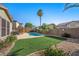 Backyard with lush turf, a pool, and a patio set for outdoor dining at 249 Cinnamon Ridge Way, Henderson, NV 89015