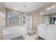 A full bathroom features a bathtub, shower, vanity and window at 249 Cinnamon Ridge Way, Henderson, NV 89015
