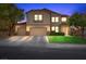 Charming two-story home featuring a three-car garage and well-manicured front lawn at twilight at 249 Cinnamon Ridge Way, Henderson, NV 89015