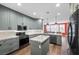 Stylish kitchen with gray cabinets, granite countertops, stainless steel appliances, and kitchen island at 249 Cinnamon Ridge Way, Henderson, NV 89015