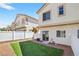 Backyard with a small patch of synthetic grass, gravel, and surrounded by a white fence at 2558 Lazy Saddle Dr, Henderson, NV 89002