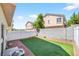 A lovely backyard with a patch of synthetic grass, gravel, and surrounded by a fence and wall at 2558 Lazy Saddle Dr, Henderson, NV 89002
