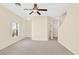 Expansive room with a ceiling fan, window, carpet, and access to other rooms in the house at 2558 Lazy Saddle Dr, Henderson, NV 89002