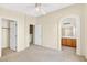 Spacious bedroom with neutral carpet, ceiling fan, closet, and an arched doorway to the bathroom at 2558 Lazy Saddle Dr, Henderson, NV 89002