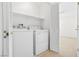 Neat laundry room with a washer, dryer, shelving, and louvered door at 2558 Lazy Saddle Dr, Henderson, NV 89002