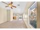 Bright living room featuring a ceiling fan, neutral carpet, and natural light at 2558 Lazy Saddle Dr, Henderson, NV 89002