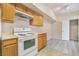 Practical kitchen with wood cabinets, white appliances, and an oven for easy meal preparation and cleanup at 2615 W Gary Ave # 1053, Las Vegas, NV 89123