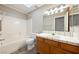 Bright bathroom features a shower and tub combination, a vanity with decorative tile, and a skylight at 2950 Winchester Ave, Pahrump, NV 89048