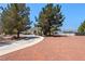 Single-story home featuring mature landscaping, a large circular driveway, and mountain views at 2950 Winchester Ave, Pahrump, NV 89048