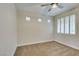 Clean, minimalist bedroom with carpet flooring, three windows, and neutral color scheme at 4963 Crooked Stick Way, Las Vegas, NV 89113
