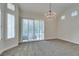 Spacious bedroom featuring plush carpet, bright windows with shutters, and decorative chandelier at 4963 Crooked Stick Way, Las Vegas, NV 89113