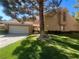 Inviting home featuring a two-car garage, manicured lawn, and mature landscaping at 4963 Crooked Stick Way, Las Vegas, NV 89113