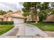 Charming home features a large driveway, mature trees, manicured landscaping, and two-car garage at 4963 Crooked Stick Way, Las Vegas, NV 89113