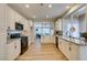 Well-lit kitchen with modern appliances, granite countertops, and white cabinets with an adjacent living room at 4963 Crooked Stick Way, Las Vegas, NV 89113