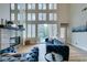 Bright living room with a fireplace, tall windows, and a blue velvet sofa overlooking a lush outdoor view at 4963 Crooked Stick Way, Las Vegas, NV 89113