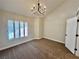 Living room featuring shuttered windows, neutral walls, and a chandelier at 4963 Crooked Stick Way, Las Vegas, NV 89113