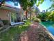 Back patio with seating area, manicured lawn, and water views at 4963 Crooked Stick Way, Las Vegas, NV 89113