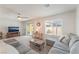 Cozy living room with plush carpet, a ceiling fan, and natural light, perfect for relaxation at 518 Descubir Ave, North Las Vegas, NV 89081