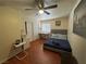 Bedroom featuring wood flooring, a ceiling fan, a comfy bed, and a desk, creating a welcoming atmosphere at 5499 Indian River Dr # 356, Las Vegas, NV 89103