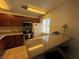 Well-lit kitchen featuring tiled floors, wooden cabinets, modern appliances, and a granite countertop at 5499 Indian River Dr # 356, Las Vegas, NV 89103