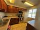Functional kitchen with tiled floors, wooden cabinets, modern appliances, and laminate countertops at 5499 Indian River Dr # 356, Las Vegas, NV 89103