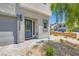 Modern home entrance with a gray front door, minimalist landscaping, and a cobblestone driveway at 5804 Gossamer Stone Ct, Las Vegas, NV 89141