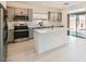 Modern kitchen with stainless steel appliances, an island, gray cabinets, and tiled floors at 5804 Gossamer Stone Ct, Las Vegas, NV 89141