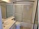 Bright bathroom featuring a shower with sliding glass doors, tiled walls, and a well-lit vanity area at 6636 Old Oxford Ave, Las Vegas, NV 89108