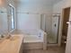 Bright bathroom featuring a large tub and a glass-enclosed shower at 6636 Old Oxford Ave, Las Vegas, NV 89108