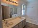 Bathroom featuring double sinks, a vanity, and separate tub and shower at 6636 Old Oxford Ave, Las Vegas, NV 89108