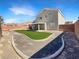 Spacious backyard with a covered patio, lush green lawn, gravel accents and mountain views at 6696 Merced Lake Dr, Las Vegas, NV 89156