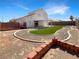Expansive backyard featuring synthetic grass, a covered patio, and decorative landscaping at 6696 Merced Lake Dr, Las Vegas, NV 89156