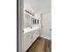 Well-lit bathroom features a white vanity, cabinets, and wood-look flooring at 6696 Merced Lake Dr, Las Vegas, NV 89156
