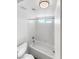 Bright bathroom includes a white tiled shower-tub, toilet and a small window for ventilation at 6696 Merced Lake Dr, Las Vegas, NV 89156