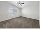 Empty bedroom with plush gray carpet, ample natural light, and fresh white walls at 6696 Merced Lake Dr, Las Vegas, NV 89156
