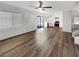 Open-concept living room featuring wood floors, shutter-style blinds, and a view into the kitchen at 6696 Merced Lake Dr, Las Vegas, NV 89156
