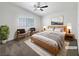 Light-filled main bedroom featuring a ceiling fan, a large window, and neutral carpeting at 6696 Merced Lake Dr, Las Vegas, NV 89156