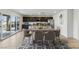 Open-concept dining area with modern furnishings, seamlessly connected to a well-equipped kitchen and outdoor patio at 6850 Magenta Moon St, North Las Vegas, NV 89086