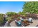 A cozy backyard patio with brick pavers, a seating area, lush landscaping, and privacy fencing at 694 Value Ridge Ave, Henderson, NV 89012