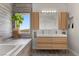 Serene bathroom with double vanity, wood cabinets, and views from the soaking tub window at 694 Value Ridge Ave, Henderson, NV 89012