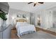 Bedroom has a large bed, ceiling fan, hardwood floors, and entryways to the bathroom at 694 Value Ridge Ave, Henderson, NV 89012